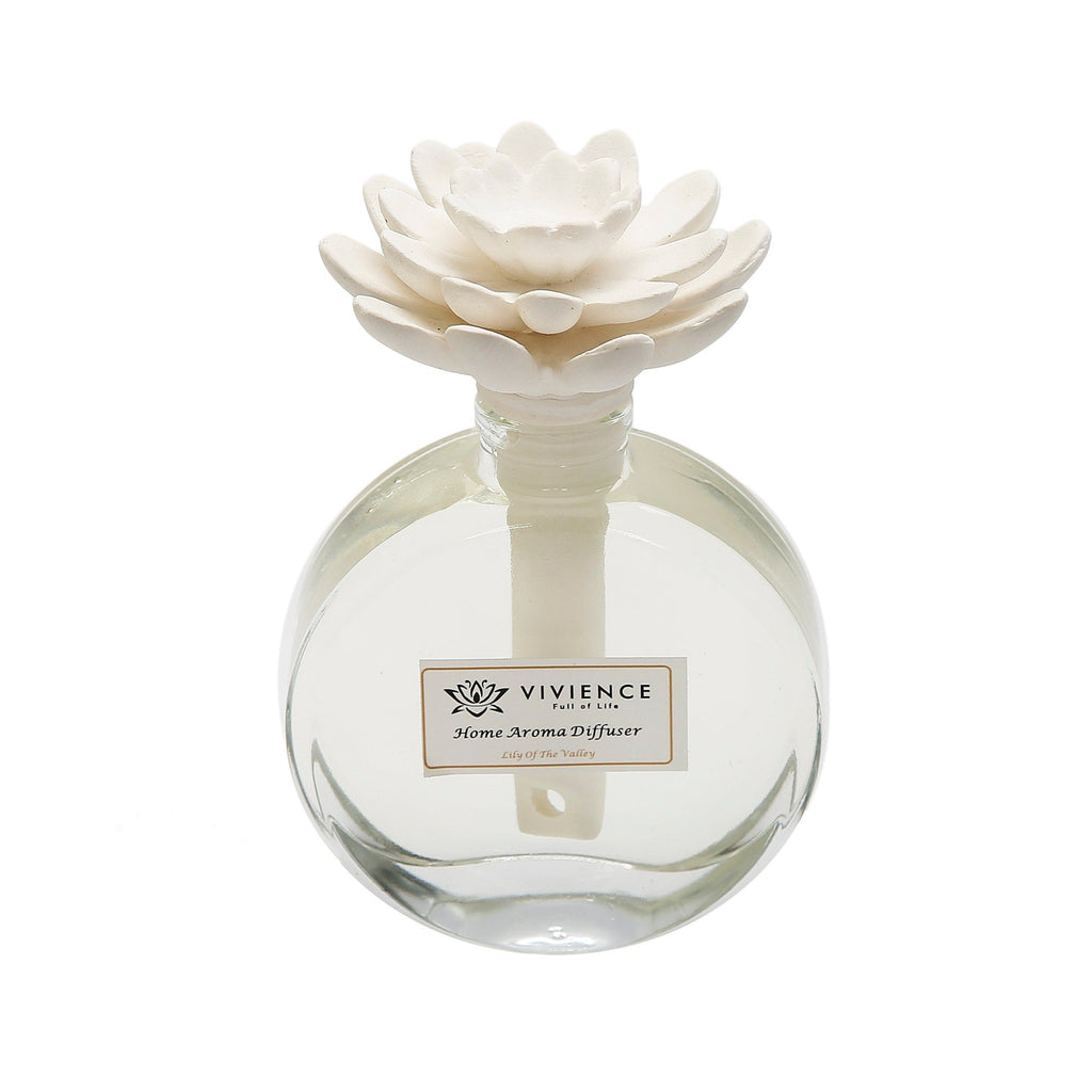 Bottle with essential oil and lily-of-the-valley flowers on white